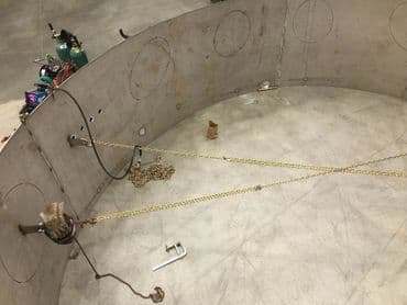 Industrial metal structure with chains and tools, showcasing construction work environment.