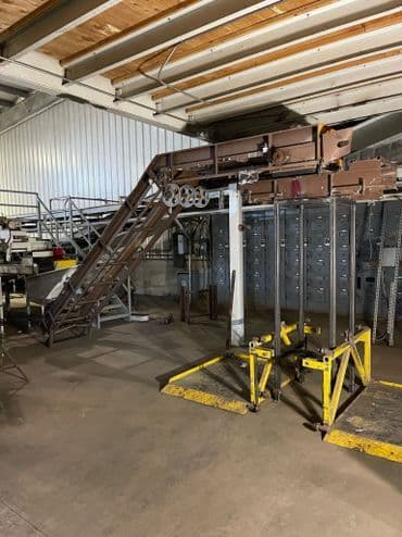 Industrial metal staircase and lift equipment in a warehouse setting.