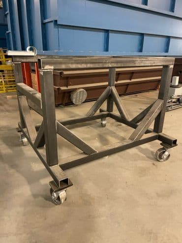 Industrial metal workbench on wheels with a sturdy frame and cross bracing.
