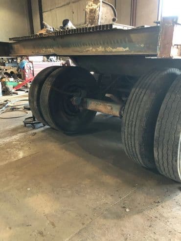 Truck chassis showing rear wheel assembly in a workshop setting.