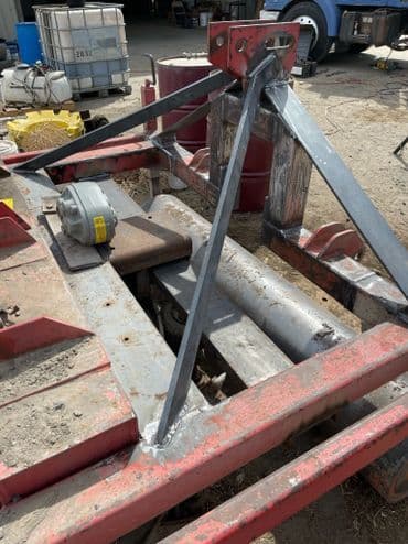 Metal farming equipment with welded supports and a flat base, used for agricultural tasks.