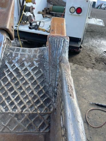 Detailed close-up of a metal piece showing weld patterns and textured surface equipment.