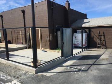 Exterior construction site with concrete slab and steel framework for a building renovation.