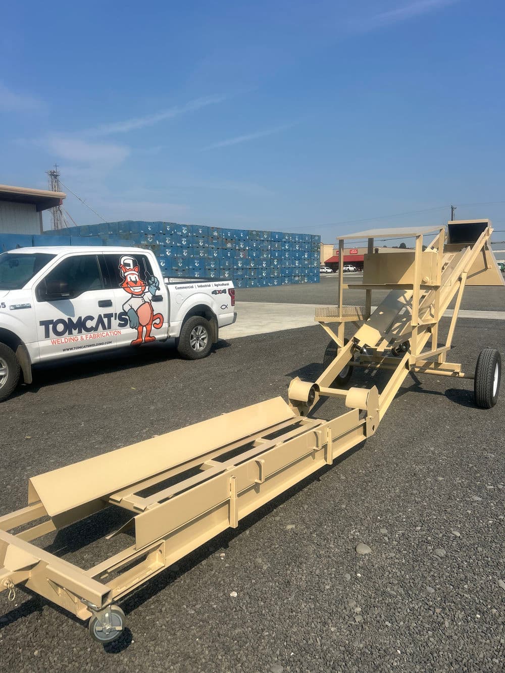 Tomcat's machinery with truck in background, set against a clear blue sky.